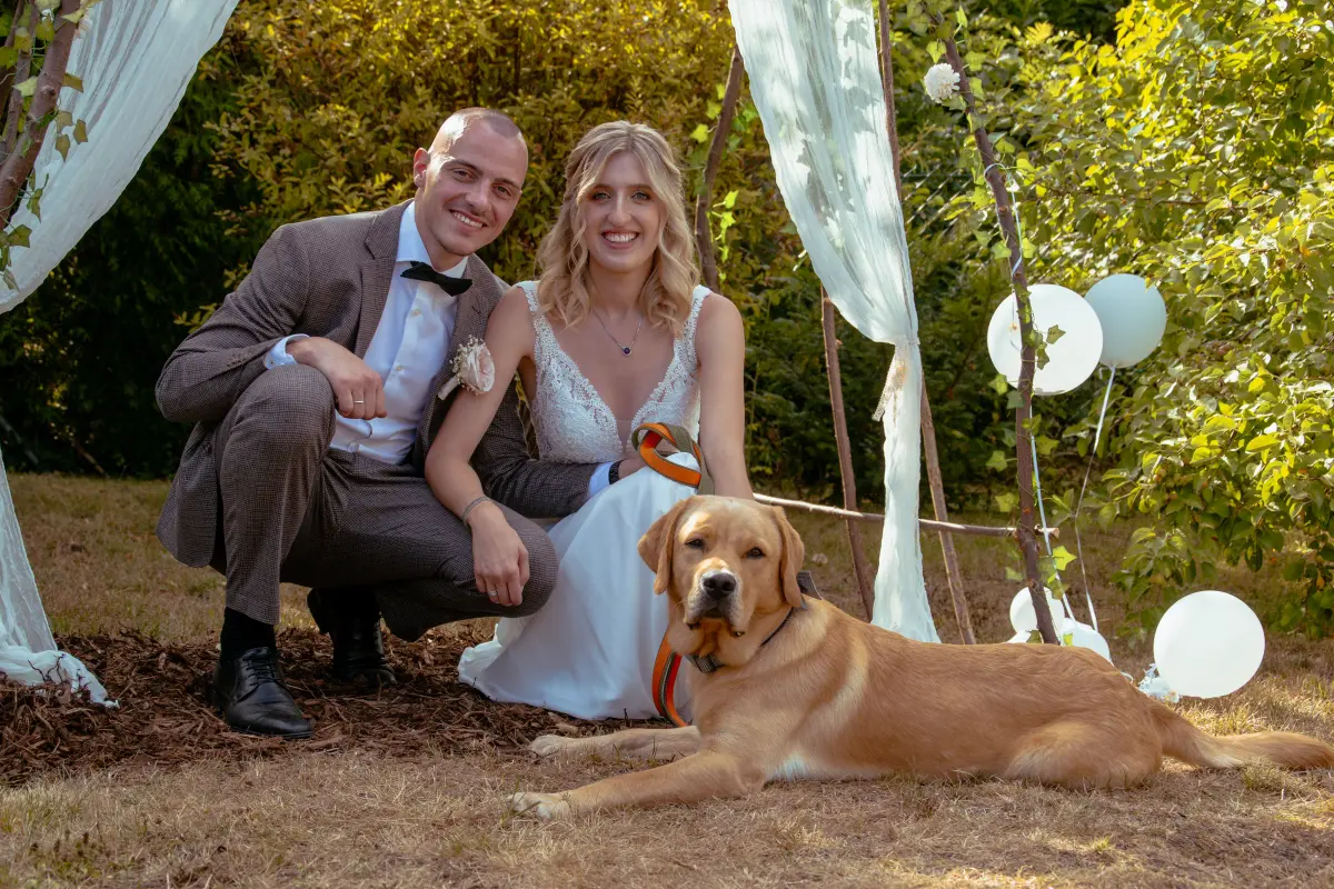 Brautpaar mit ihrem Hund im Garten